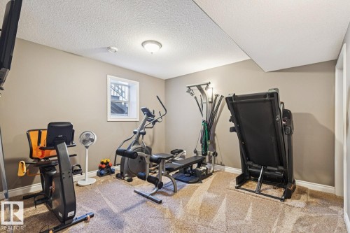 The room features neutral wall paint, a window, and carpeted flooring - 11409 63 Street Nw, Edmonton, AB - Indoor Photo Showing Gym Room