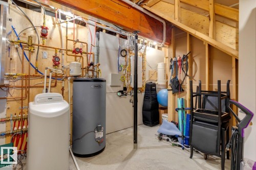 Utility area featuring exposed copper piping, a water heater, and a water softening system - 11409 63 Street Nw, Edmonton, AB - Indoor Photo Showing Basement