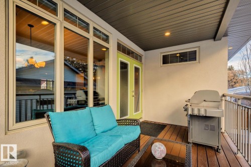 The property features a covered outdoor patio with wood decking and a light green double door entry - 11409 63 Street Nw, Edmonton, AB - Outdoor With Deck Patio Veranda With Exterior