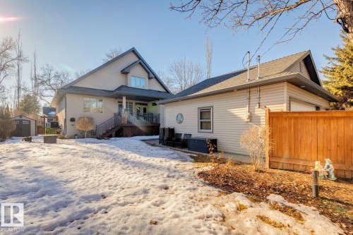 The property features an extensive yard with a detached garage, a wooden fence, and a storage shed - 11409 63 Street Nw, Edmonton, AB - Outdoor