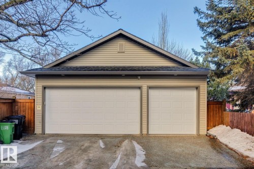 The property features a garage with two distinct garage doors and beige siding - 11409 63 Street Nw, Edmonton, AB - Outdoor