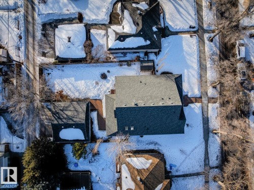 This property features a dark gray shingled roof, surrounded by a yard with snow cover - 11409 63 Street Nw, Edmonton, AB - Outdoor