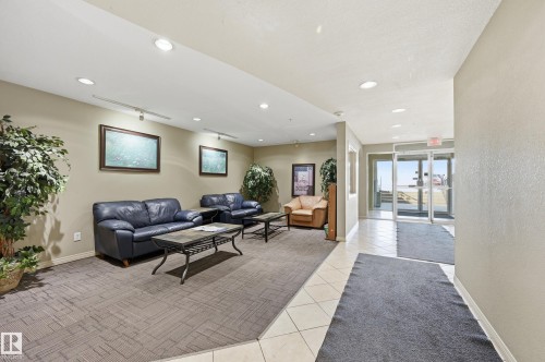 The property features a welcoming common area with recessed lighting, tile flooring, and broadloom carpet - 314 2430 Guardian Road, Edmonton, AB - Indoor Photo Showing Other Room