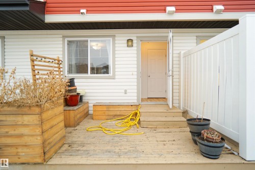 The property features a wooden deck with a privacy fence, an exterior door, and a window - 13 3751 12 Street, Edmonton, AB - Outdoor With Deck Patio Veranda With Exterior