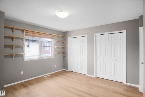 This bright room features light-colored flooring, neutral-toned walls, and a window with a wooden blind - 13 3751 12 Street, Edmonton, AB - Indoor