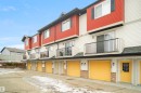 Exterior view of the property showcasing red and white siding, yellow garage doors, and balconies with black railings - 13 3751 12 Street, Edmonton, AB  - Outdoor With Exterior 