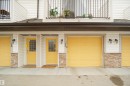 The property features white horizontal siding, yellow garage doors, and yellow entry doors with windowpanes - 13 3751 12 Street, Edmonton, AB  - Outdoor With Exterior 