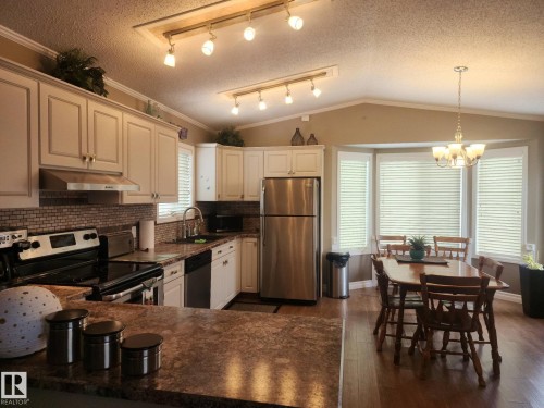 The kitchen features white cabinetry, stainless steel appliances, and a tiled backsplash - 46 Willow Park Estates, Leduc, AB - Indoor Photo Showing Kitchen