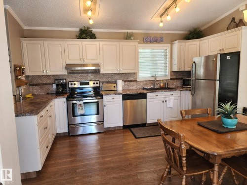 The room features light-colored carpet, a ceiling light fixture, and a white door with a silver handle - 46 Willow Park Estates, Leduc, AB - Indoor Photo Showing Bedroom