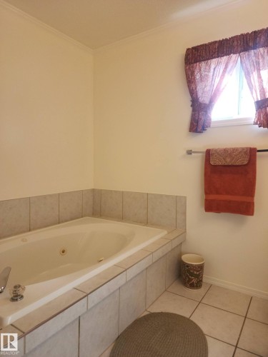 Bathroom featuring a tiled corner bathtub and tiled flooring - 46 Willow Park Estates, Leduc, AB - Indoor Photo Showing Bathroom