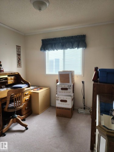 The room features neutral-toned carpet, a window with horizontal blinds, and a ceiling light fixture - 46 Willow Park Estates, Leduc, AB - Indoor