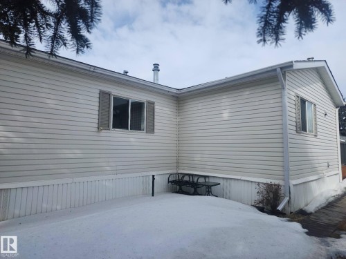 The property features light-colored horizontal siding and a window with shutters - 46 Willow Park Estates, Leduc, AB - Outdoor With Exterior