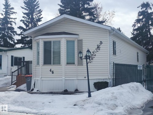The property features horizontal siding, a bay window with blinds, and a decorative outdoor lamp post - 46 Willow Park Estates, Leduc, AB - Outdoor