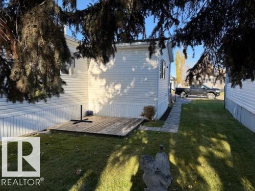 The property features a well-maintained lawn, a wooden deck, and a paved walkway - 46 Willow Park Estates, Leduc, AB - Outdoor