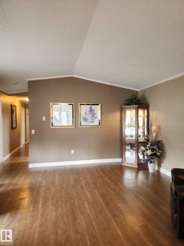 The living area features hardwood style flooring and a vaulted ceiling - 46 Willow Park Estates, Leduc, AB - Indoor
