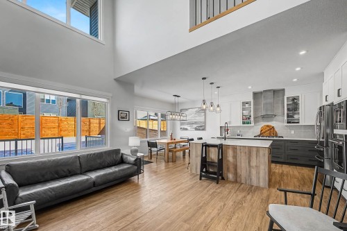 The open concept living area features high ceilings, light wood-style flooring, and large windows - 34 Riverhill Crescent, St. Albert, AB - Indoor
