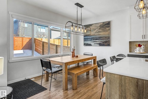 This dining area features hardwood flooring and an expansive window providing natural light - 34 Riverhill Crescent, St. Albert, AB - Indoor Photo Showing Dining Room