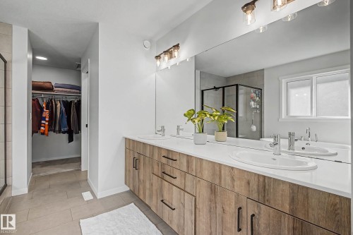 Bathroom featuring a double vanity with light wood cabinetry, white countertops, and a large mirror - 34 Riverhill Crescent, St. Albert, AB - Indoor Photo Showing Bathroom
