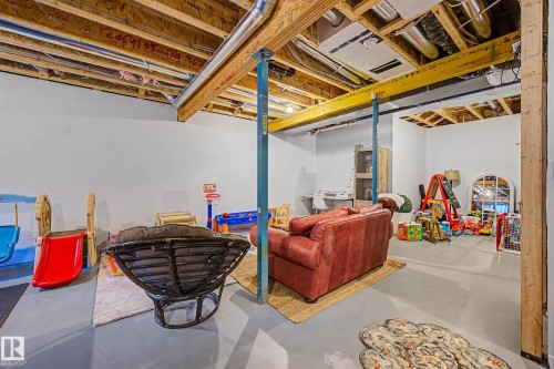 This expansive basement area features a finished floor, white walls, and exposed ceiling joists with visible ductwork - 34 Riverhill Crescent, St. Albert, AB - Indoor Photo Showing Basement