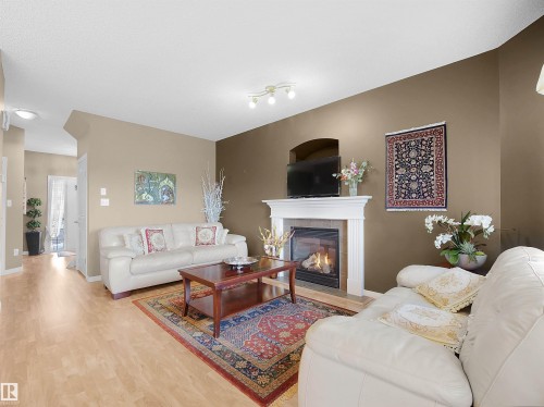 Living room featuring light wood-style floors and a fireplace - 11708 10 Avenue, Edmonton, AB - Indoor Photo Showing Living Room With Fireplace