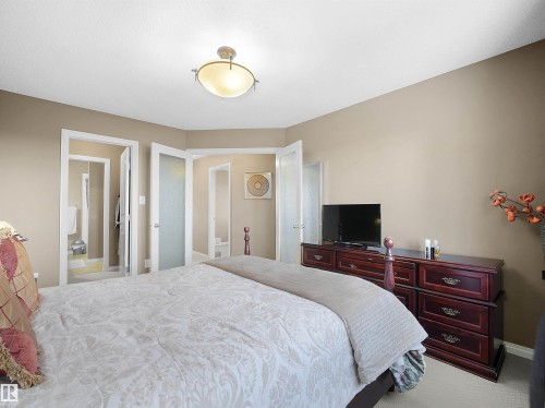 Bedroom featuring light carpet and ensuite bathroom - 11708 10 Avenue, Edmonton, AB - Indoor Photo Showing Bedroom