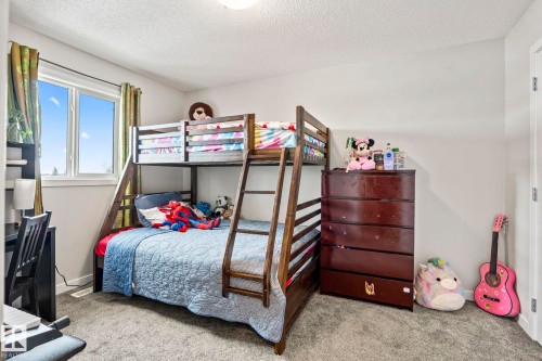 This room features a double window providing natural light, carpeted flooring, and white walls - 483 Ebbers Way Nw, Edmonton, AB - Indoor Photo Showing Bedroom