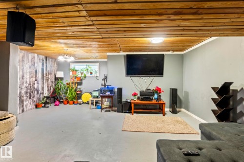 The property features a spacious room with a wood plank ceiling and painted walls - 483 Ebbers Way Nw, Edmonton, AB - Indoor