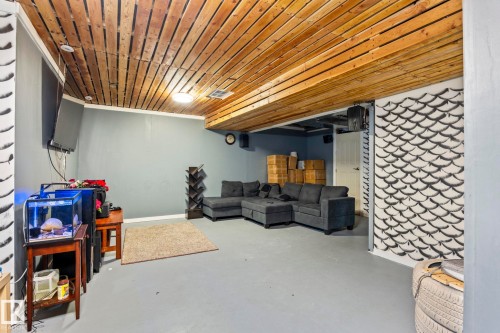 Living area featuring a wooden plank ceiling, light gray walls, and a light gray floor - 483 Ebbers Way Nw, Edmonton, AB - Indoor Photo Showing Basement