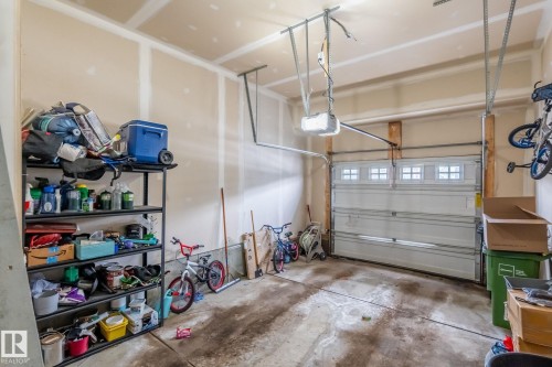 The garage features an automatic overhead door with windows, providing both convenience and natural light - 483 Ebbers Way Nw, Edmonton, AB - Indoor Photo Showing Garage