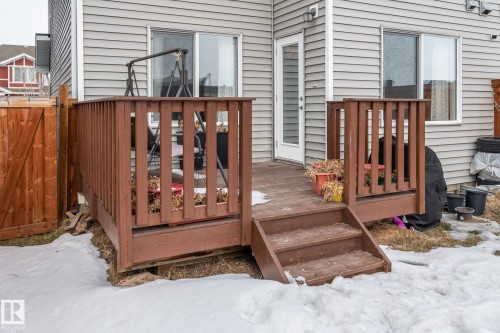 The property features a wooden deck with railing, accessible via a set of wooden steps - 483 Ebbers Way Nw, Edmonton, AB - Outdoor
