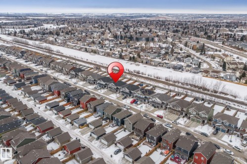 An aerial view of the property and its surrounding neighborhood, featuring residential homes with varied exterior colors and roof styles - 483 Ebbers Way Nw, Edmonton, AB - Outdoor With View
