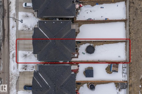Aerial view of the property, featuring a roof with dark shingles and a paved driveway - 483 Ebbers Way Nw, Edmonton, AB - 