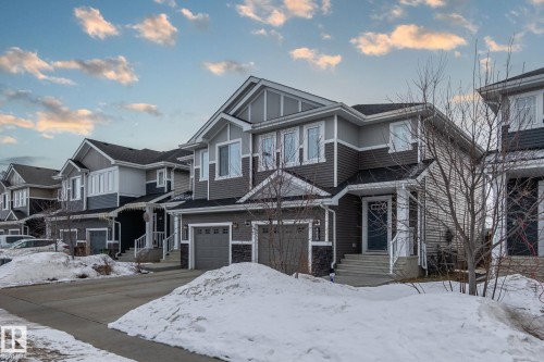 This property features a two-story exterior with dark gray siding, white trim, and a prominent front entrance with steps - 483 Ebbers Way Nw, Edmonton, AB - Outdoor With Facade