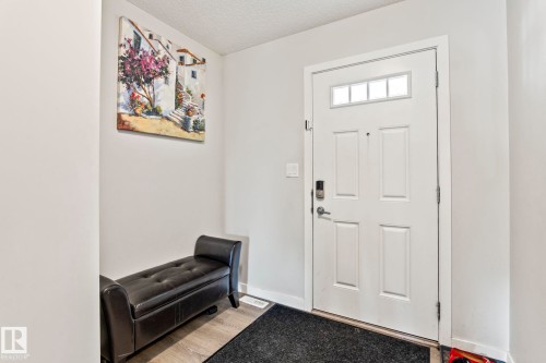 Entryway featuring a white paneled door with transom windows, a smart lock, and light-colored flooring - 483 Ebbers Way Nw, Edmonton, AB - Indoor Photo Showing Other Room