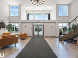 Inviting entrance area with high ceilings, large windows, and tiled flooring - 