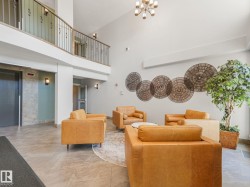 Inviting lobby area with a high ceiling, light-colored walls, and tiled flooring - 