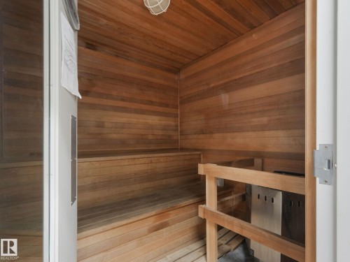 The property includes a sauna with extensive wood paneling and wood benches, featuring a metal heater unit - 412 12408 15 Avenue, Edmonton, AB - Indoor Photo Showing Other Room