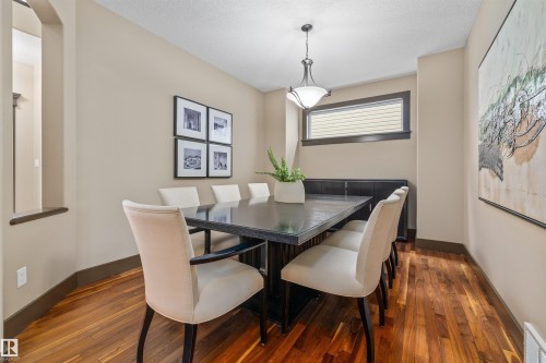 The dining area features hardwood floors and a contemporary light fixture - 1014 Hope Road, Edmonton, AB - Indoor Photo Showing Dining Room