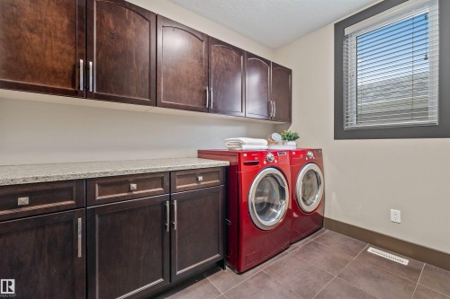 Laundry room featuring dark wood cabinetry, a light-colored countertop, and a window with horizontal blinds - 1014 Hope Road, Edmonton, AB - Indoor Photo Showing Laundry Room