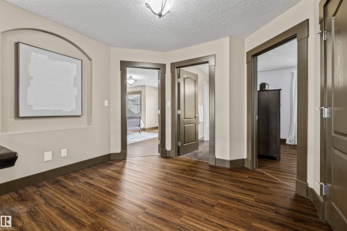 The property features durable wood-look flooring and doorways with dark trim - 1014 Hope Road, Edmonton, AB - Indoor Photo Showing Other Room