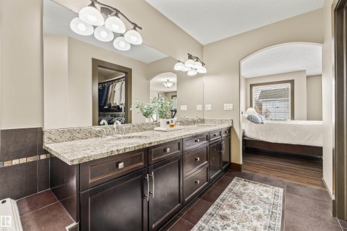 This bathroom features a double vanity with granite countertops and dark wood cabinetry - 1014 Hope Road, Edmonton, AB - Indoor