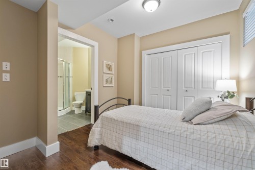 This room features hardwood flooring, neutral wall tones, and a closet with bifold doors - 1014 Hope Road, Edmonton, AB - Indoor Photo Showing Bedroom