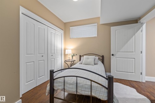 This room features hardwood flooring, white paneled doors, and a neutral wall color - 1014 Hope Road, Edmonton, AB - Indoor Photo Showing Bedroom