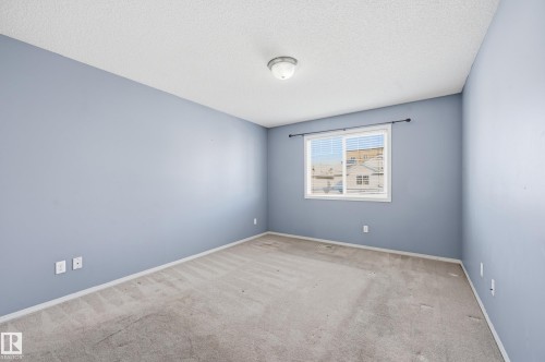 This room features light blue walls, a window with blinds, and carpeted flooring - 53 287 Macewan Road, Edmonton, AB - Indoor Photo Showing Other Room
