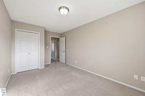 This room features light-colored carpeting, neutral painted walls, and white trim - 53 287 Macewan Road, Edmonton, AB - Indoor Photo Showing Other Room