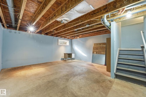 The property features an unfinished basement with a concrete floor, exposed ceiling joists, light blue walls, and a visible window - 53 287 Macewan Road, Edmonton, AB - Indoor Photo Showing Basement