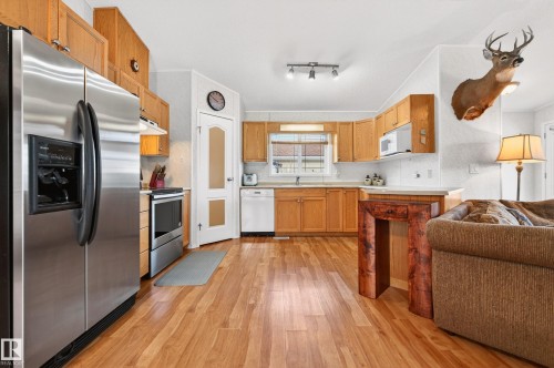The kitchen features wood cabinetry, stainless steel appliances, and wood flooring - 1727 Jubilee Loop, Sherwood Park, AB - Indoor Photo Showing Kitchen With Stainless Steel Kitchen