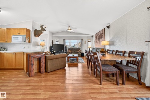 The open-concept living space features hardwood floors, a dining area with a wooden table, and a kitchen with light wood cabinetry and a white countertop - 1727 Jubilee Loop, Sherwood Park, AB - Indoor