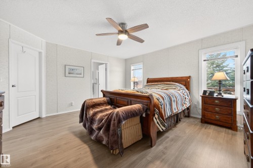 This bedroom features light wood-look flooring, white walls, and a ceiling fan - 1727 Jubilee Loop, Sherwood Park, AB - Indoor Photo Showing Bedroom
