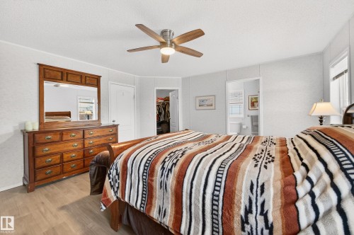 This room features light-colored walls, a ceiling fan with integrated lighting, and durable flooring - 1727 Jubilee Loop, Sherwood Park, AB - Indoor Photo Showing Bedroom